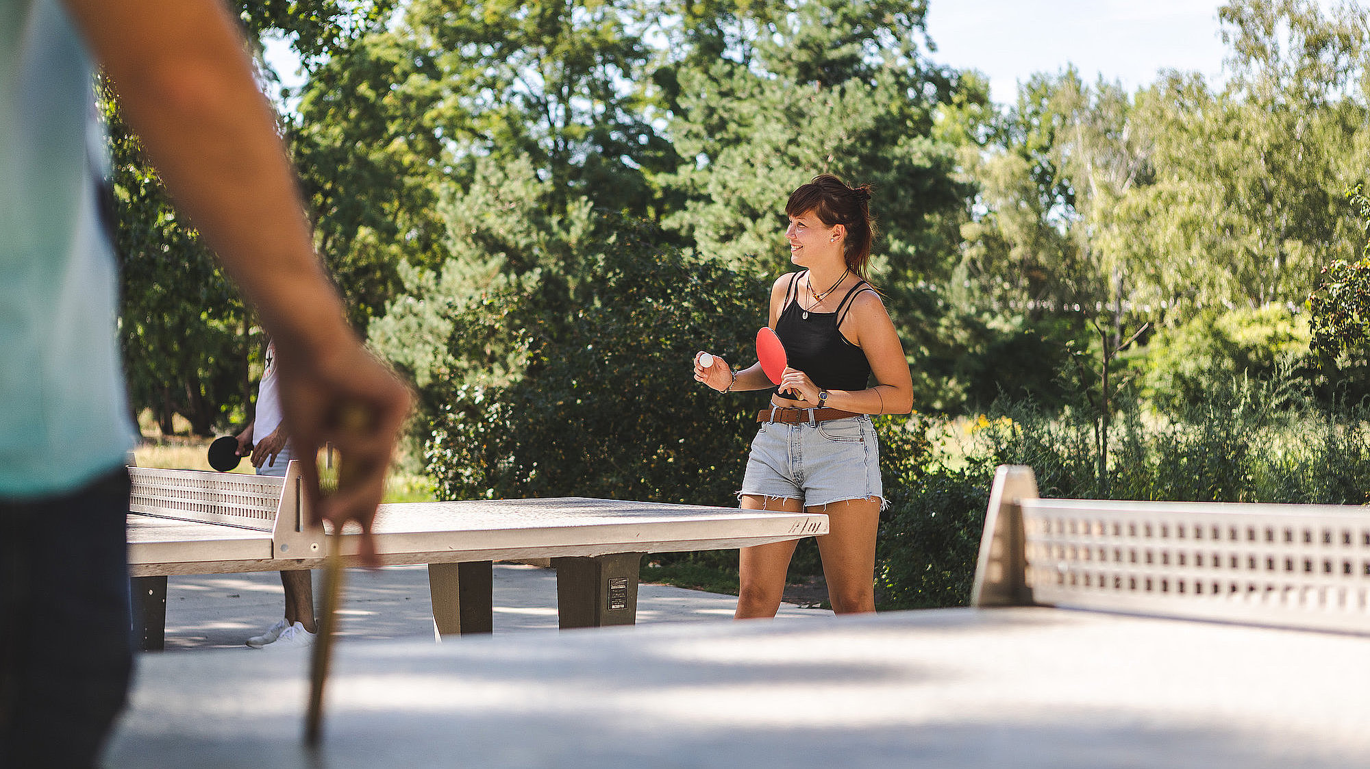 Eine Frau spiel Tischtennis im Park am Gleisdreieck