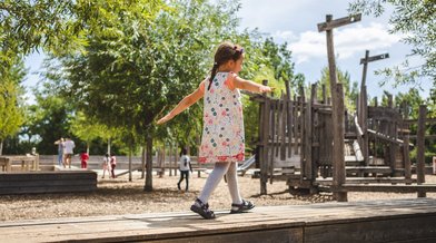 Ein Kind balanciert auf einem Spielplatz im Park am Gleisdreieck